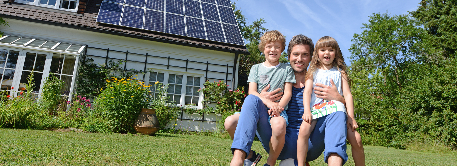 Familie vor Ihrem Haus mit Photovoltaikanlage
